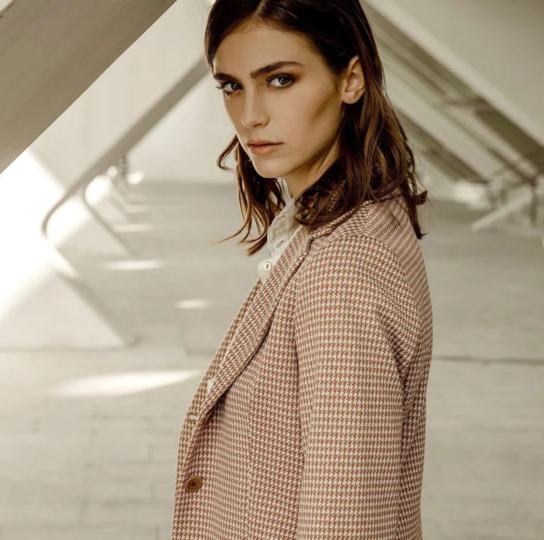 Modella con giacca beige dalla texture melange e revers sartoriali
