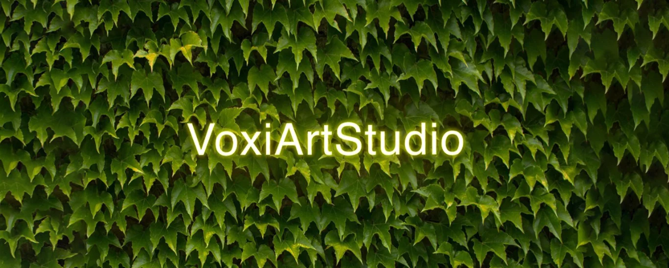 Parete ricoperta di vegetazione verde con insegna luminosa Voxi Art Studio