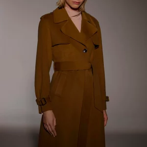 Modella con cappotto lungo marrone doppiopetto e cintura in vita
