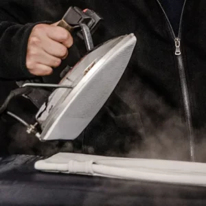 Stiratura professionale a vapore di un capo di abbigliamento durante le fasi di finitura